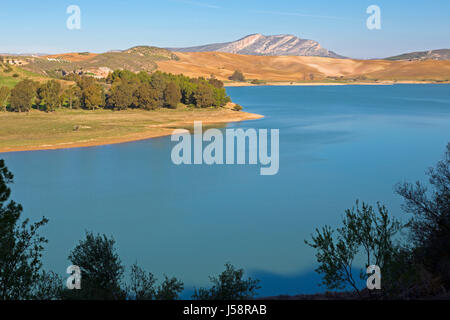 View across Guadalhorce dam, Malaga Province, Andalusia, Spain, to farmland beyond. Embalse de Conde de Guadalorce. Stock Photo