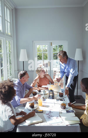 Group of executive using laptop while having breakfast in restaurant Stock Photo