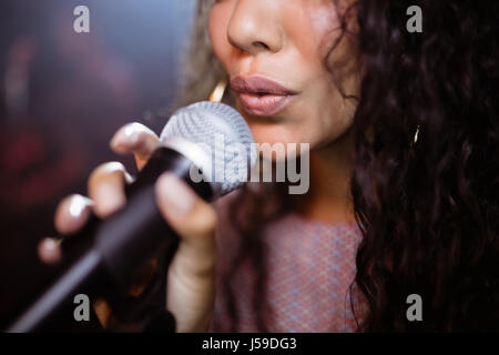 Close up of female singer singing at nightclub during music festival Stock Photo