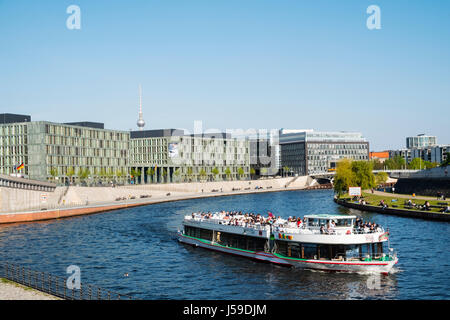 Tourist tour boat on River Spree in Berlin with modern offices to read, Germany