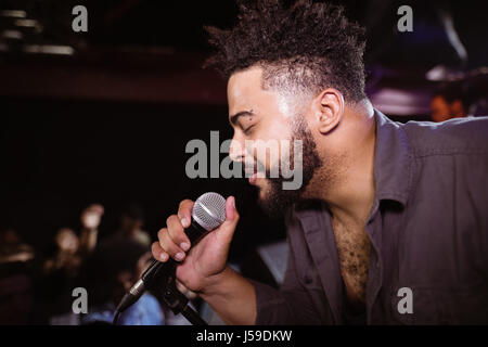 Male singer performing at nightclub during music festival Stock Photo