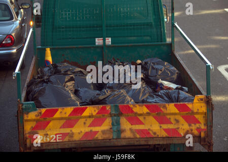 black bags full of rubbish in the back of a council lorry or truck Stock Photo
