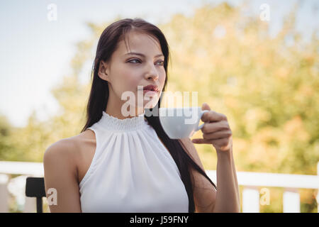 Thoughtful young woman having coffee at home Stock Photo