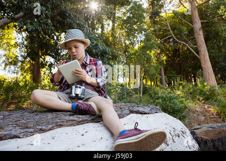 Concentrated boy using his digital tablet in the forest Stock Photo