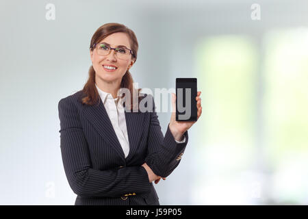 Portrait of a beautiful businesswoman 50 ears old with mobile phone in the office. Stock Photo