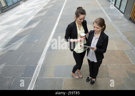 Elevated view of two Caucasian Business women using digital tablet computer. Stock Photo