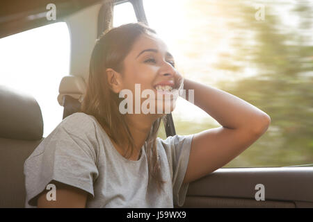 Smiling young women in car hair gets blown by the wind Stock Photo