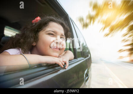 Smiling girl looking out car window Stock Photo