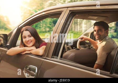 Young couple riding in car looking out car window Stock Photo