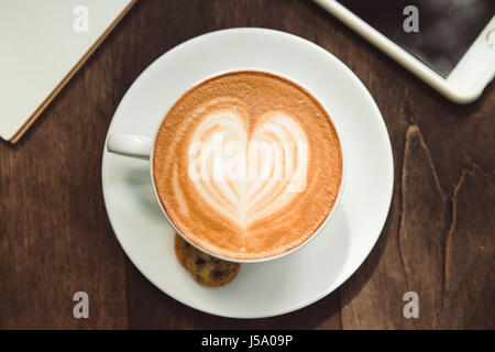 Top view latte art coffee on wooden table. Stock Photo