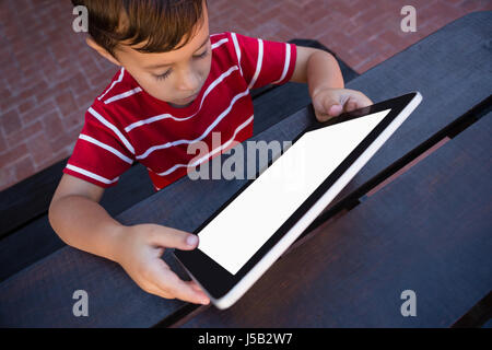 High angle view of boy using tablet while sitting at table in school Stock Photo