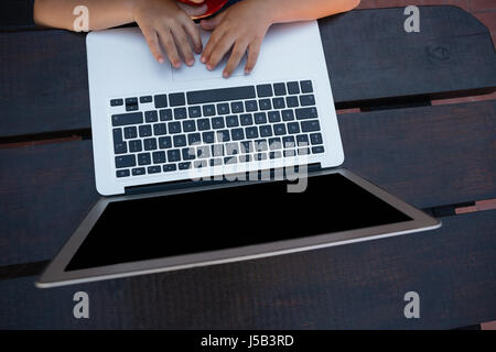 Overhead view of boy using digital laptop while sitting at table in school Stock Photo