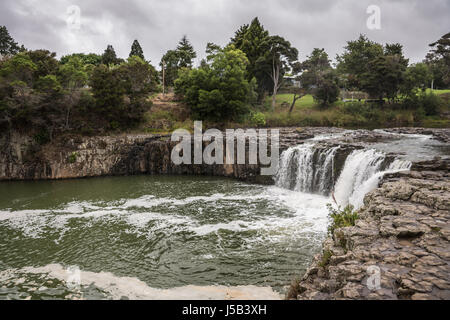 Bay of Islands, New Zealand - March 7, 2017: Haruru falls in green bush landscape under heavy cloudscape because of approaching cyclone. White water a Stock Photo