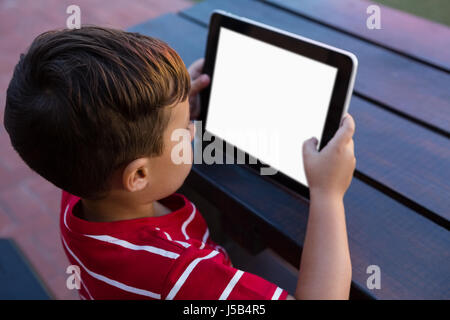 High angle view of boy using digital tablet while sitting at table in school Stock Photo