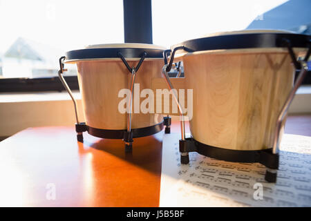 Close up of drums on table against window at classroom Stock Photo