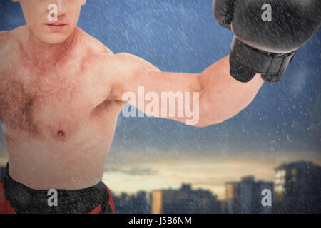 Boxer performing boxing stance against city against cloudy sky during sunset Stock Photo