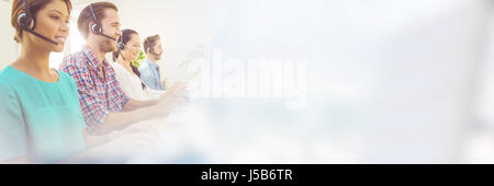 Business team working together at a call centre wearing headsets Stock Photo