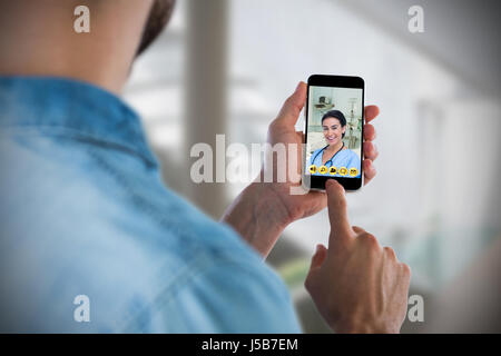 Man using mobile phone against sterile bedroom Stock Photo