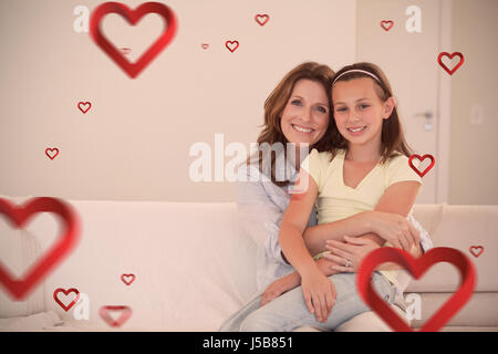 Hearts against portrait of smiling mother and daughter embracing Stock Photo