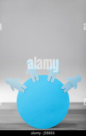 Conceptual image of blue paper cut out figures on circle Stock Photo