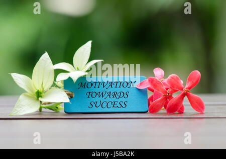 word motivation towards success written on wooden tag with flower as decoration Stock Photo