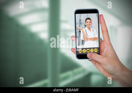 Human hand holding mobile phone against white background against sterile bedroom Stock Photo