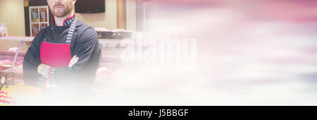 Portrait of butcher standing in meat shop with his hands crossed Stock Photo