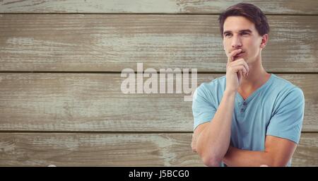Digital composite of Thoughtful man looking away against wooden wall Stock Photo