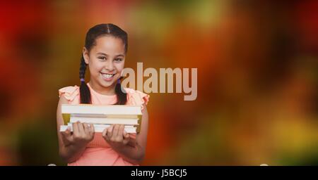 Digital composite of Girl holding books over blur background Stock Photo