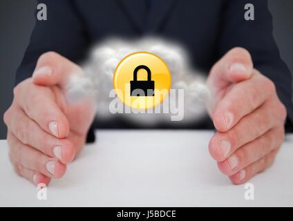 Digital composite of Business man at desk with cloud and yellow lock graphic between hands against grey background Stock Photo
