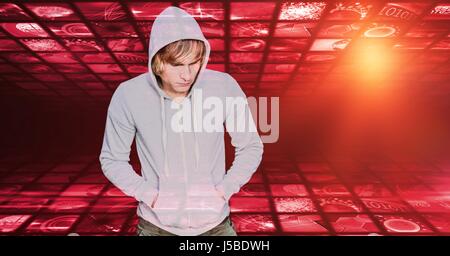 Digital composite of Hipster with hands in hooded shirt's pockets against screens Stock Photo