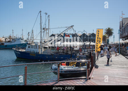 Fremantle,WA,Australia-November 13,2016: Tourists, boardwalk, fishing boats and waterfront cafe's in the harbour in Fremantle, Western Australia. Stock Photo