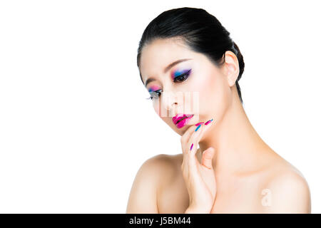 colorful make-up and nails. gorgeous black hair girl model display rainbow art on face and finger isolated on white wall. Stock Photo