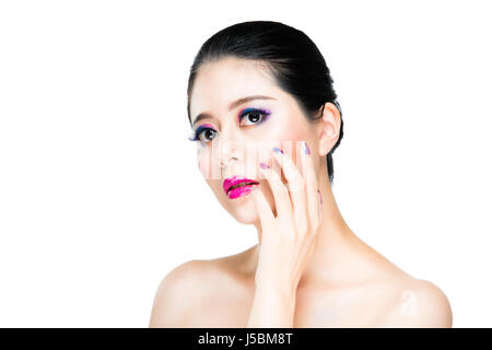 asian beautiful brunette girl makeup colorful eyeshadow and nails with bright pink lip on white wall background. concept nail painted advertising. Stock Photo