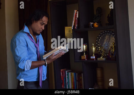 Young man looking at books, Pune, Maharashtra Stock Photo