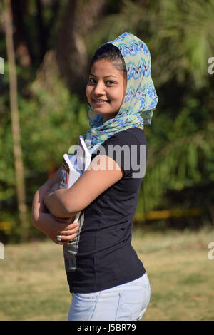 Beautiful young girl-student holding textbooks outside in the garden, Pune, Maharashtra Stock Photo