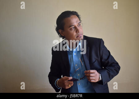 Young man with eyeglass in hand, Pune, Maharashtra Stock Photo