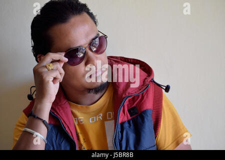 Portrait of young man in eyeglasses looking out, Pune, Maharashtra Stock Photo