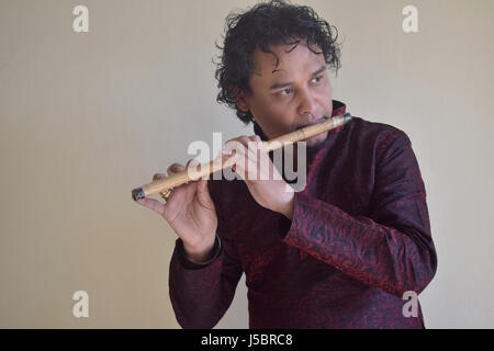 Portrait of Indian young man in a traditional attire playing flute. Pune, Maharashtra Stock Photo