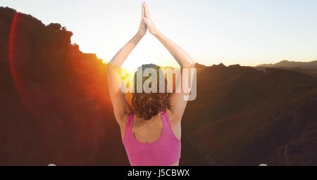 Digital composite of Double exposure of woman with hands clasped performing yoga on mountains Stock Photo