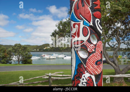 Colourful Maori carving (painted pou) in a park near Waitangi in Paihia, Bay of Islands, Northland, New Zealand Stock Photo