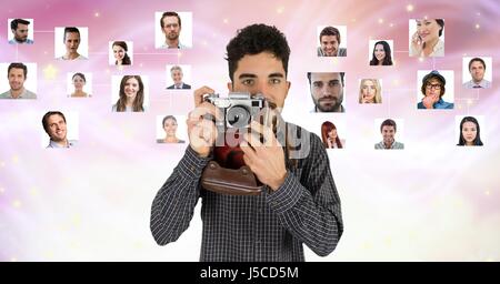 Digital composite of Confident male photographer holding camera against flying portraits Stock Photo