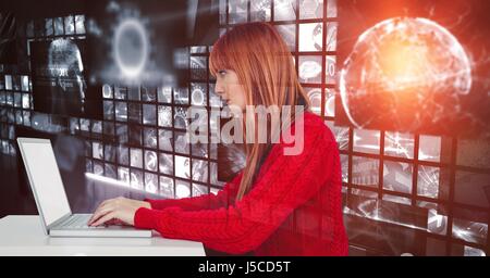 Digital composite of Female hacker using laptop against screens Stock Photo