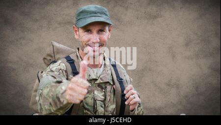 Digital composite of Soldier thumbs up with grunge overlay against brown background Stock Photo