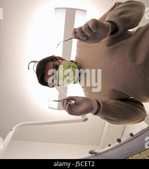 dentist with green mask and tooth care equipment in the dental clinic Stock Photo
