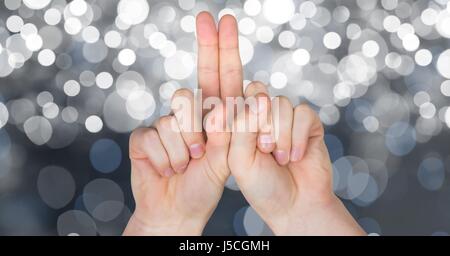 Digital composite of Cropped image of hands against glowing bokeh Stock Photo