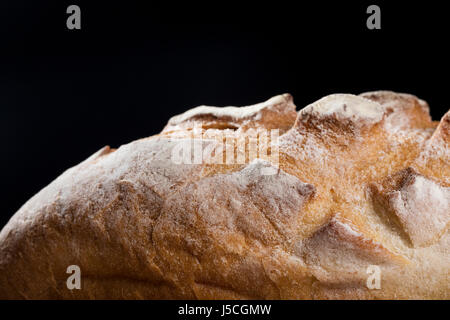 Close up view of a rustic loaf of bread on an old wooden table. Stock Photo