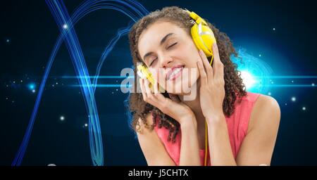 Digital composite of Young woman enjoying music on headphones Stock Photo