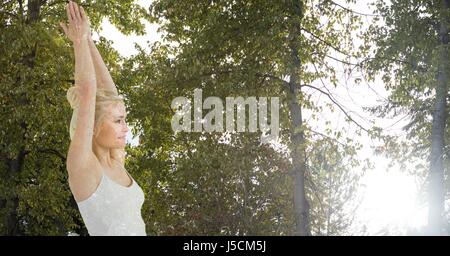 Digital composite of Double exposure of woman with hands clasped against trees Stock Photo
