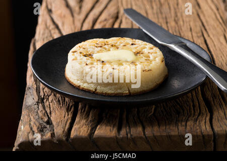 Toasted crumpets on a rustic wooden table. Stock Photo